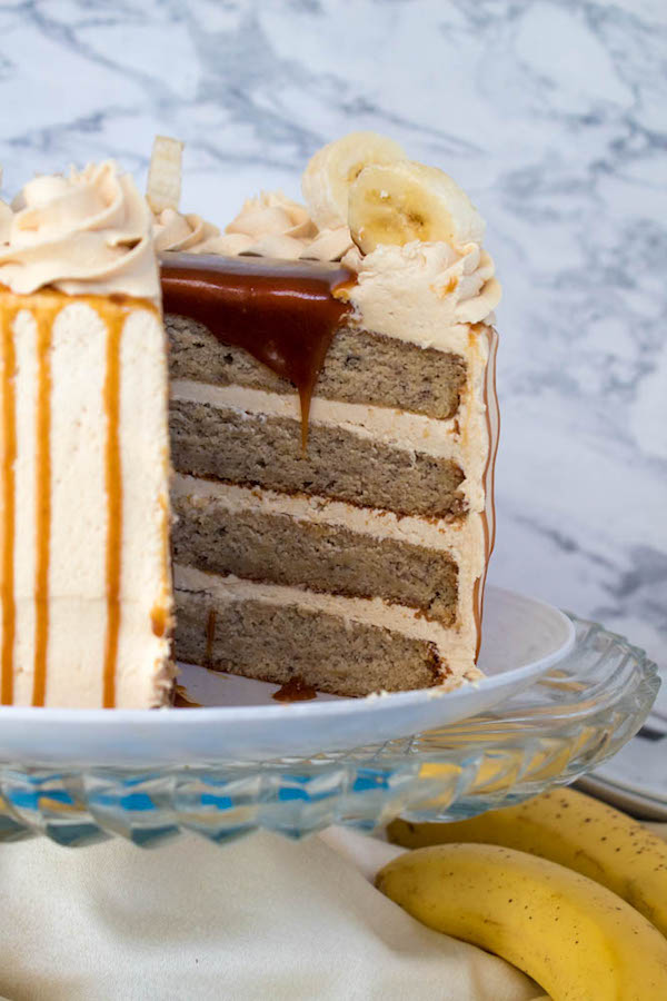 Moist and fluffy Banana cake, filled and frosted with creamy caramel buttercream, and topped with delicious homemade caramel sauce and sliced bananas. This Banana Caramel Layer Cake is the perfect dessert for birthdays, dinner parties, or any occasion!