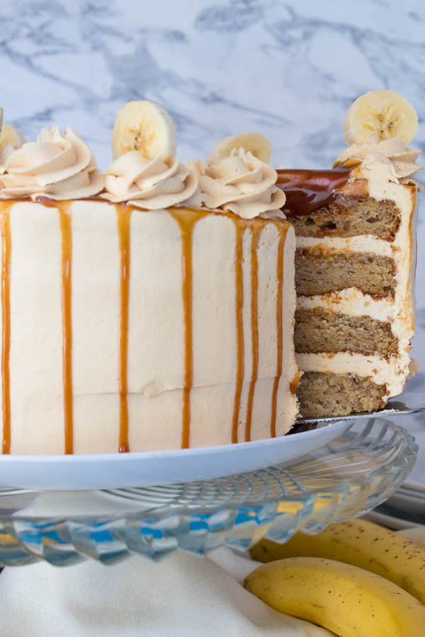 Moist and fluffy Banana cake, filled and frosted with creamy caramel buttercream, and topped with delicious homemade caramel sauce and sliced bananas. This Banana Caramel Layer Cake is the perfect dessert for birthdays, dinner parties, or any occasion!