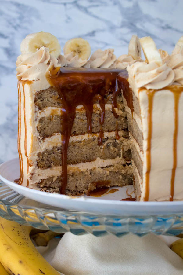 Moist and fluffy Banana cake, filled and frosted with creamy caramel buttercream, and topped with delicious homemade caramel sauce and sliced bananas. This Banana Caramel Layer Cake is the perfect dessert for birthdays, dinner parties, or any occasion!