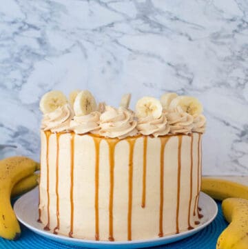 Moist and fluffy Banana cake, filled and frosted with creamy caramel buttercream, and topped with delicious homemade caramel sauce and sliced bananas. This Banana Caramel Layer Cake is the perfect dessert for birthdays, dinner parties, or any occasion!