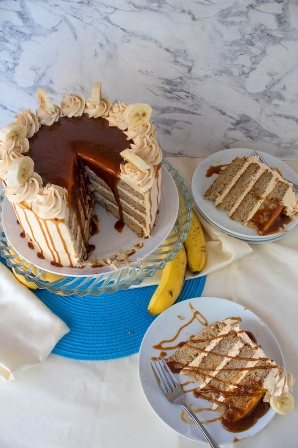 Moist and fluffy Banana cake, filled and frosted with creamy caramel buttercream, and topped with delicious homemade caramel sauce and sliced bananas. This Banana Caramel Layer Cake is the perfect dessert for birthdays, dinner parties, or any occasion!