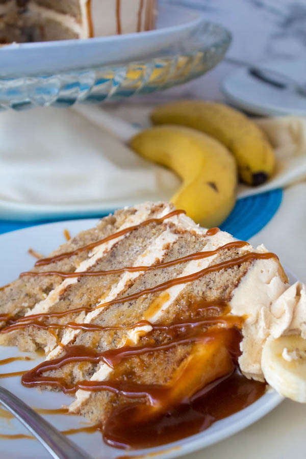 Moist and fluffy Banana cake, filled and frosted with creamy caramel buttercream, and topped with delicious homemade caramel sauce and sliced bananas. This Banana Caramel Layer Cake is the perfect dessert for birthdays, dinner parties, or any occasion!