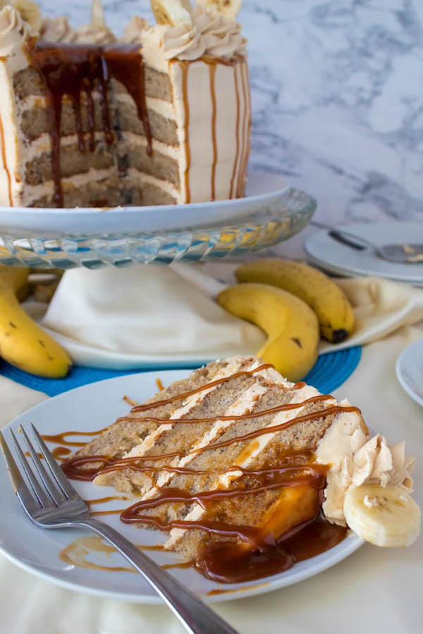 Moist and fluffy Banana cake, filled and frosted with creamy caramel buttercream, and topped with delicious homemade caramel sauce and sliced bananas. This Banana Caramel Layer Cake is the perfect dessert for birthdays, dinner parties, or any occasion!