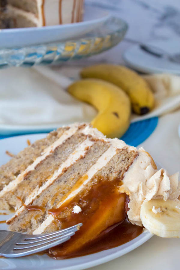 Moist and fluffy Banana cake, filled and frosted with creamy caramel buttercream, and topped with delicious homemade caramel sauce and sliced bananas. This Banana Caramel Layer Cake is the perfect dessert for birthdays, dinner parties, or any occasion!