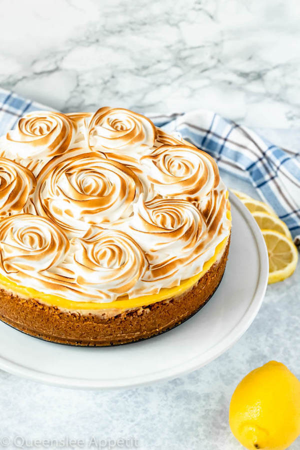 lemon meringue cheesecake with graham cracker crust, lemon cheesecake, lemon curd topping, meringue rosettes