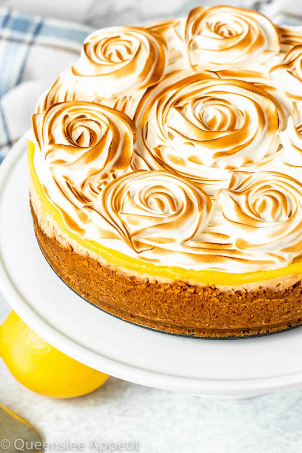 lemon meringue cheesecake with graham cracker crust, lemon cheesecake, lemon curd topping, meringue rosettes