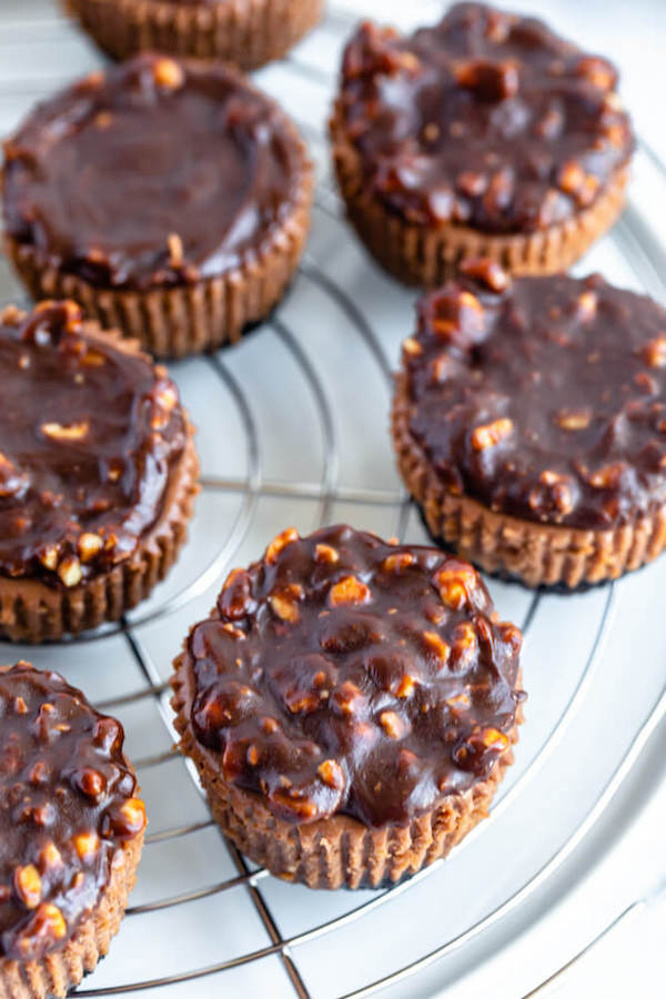 mini nutella cheesecakes stuffed with Ferrero rochers and topped with nutella hazelnut ganache, chocolate whipped cream and chopped hazelnuts 