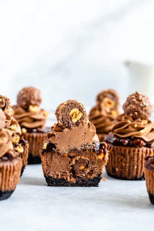 mini nutella cheesecakes stuffed with Ferrero rochers and topped with nutella hazelnut ganache, chocolate whipped cream and chopped hazelnuts