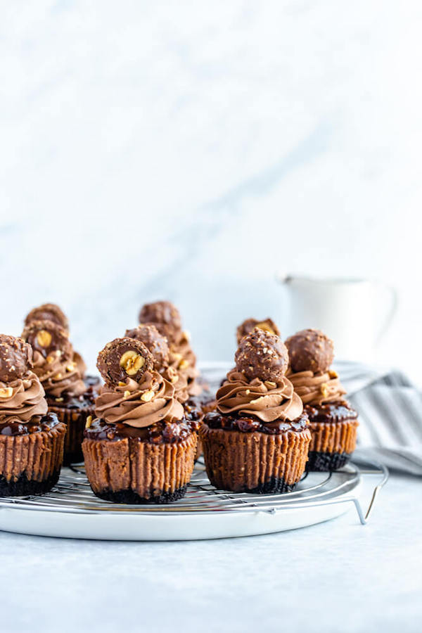 mini nutella cheesecakes stuffed with Ferrero rochers and topped with nutella hazelnut ganache, chocolate whipped cream and chopped hazelnuts 