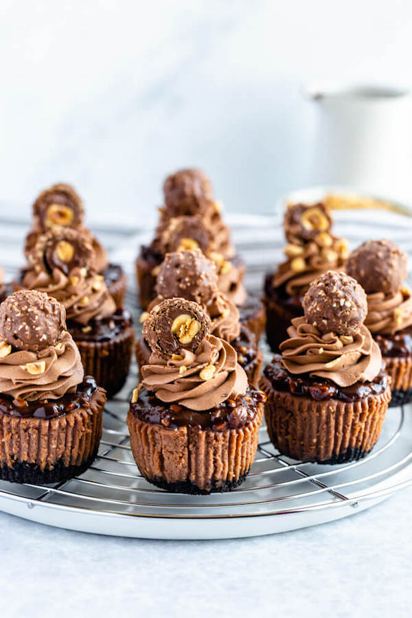 mini nutella cheesecakes stuffed with Ferrero rochers and topped with nutella hazelnut ganache, chocolate whipped cream and chopped hazelnuts 