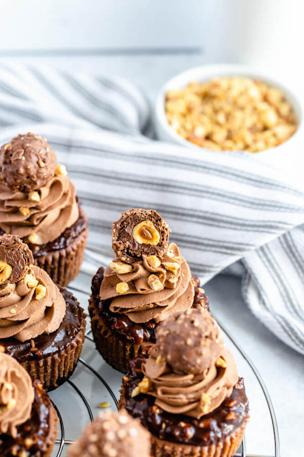 mini nutella cheesecakes stuffed with Ferrero rochers and topped with nutella hazelnut ganache, chocolate whipped cream and chopped hazelnuts 