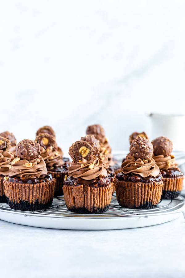 mini nutella cheesecakes stuffed with Ferrero rochers and topped with nutella hazelnut ganache, chocolate whipped cream and chopped hazelnuts 