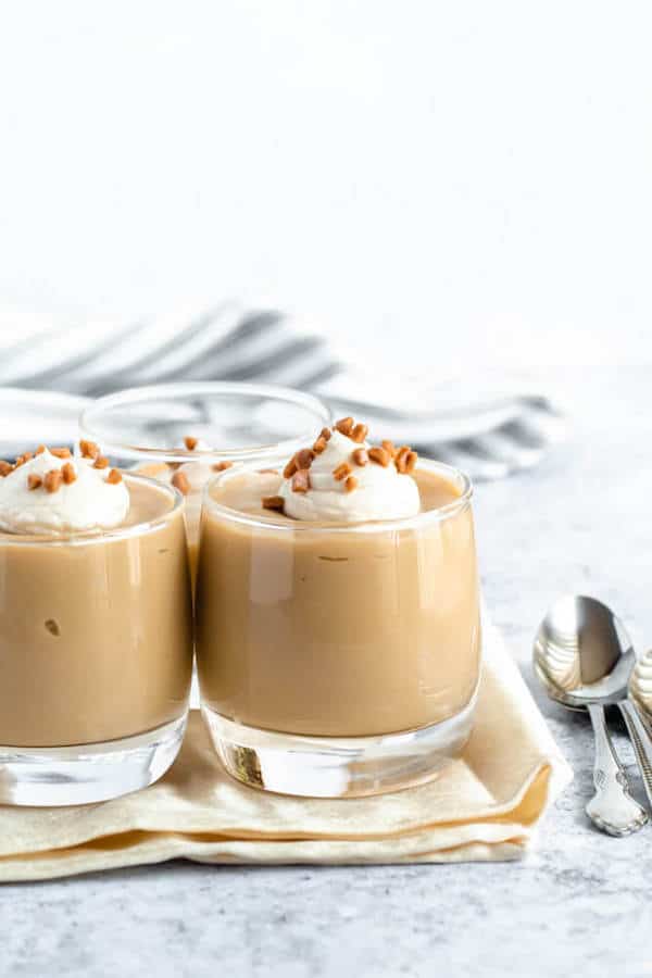 homemade butterscotch pudding topped with whipped cream and toffee bits