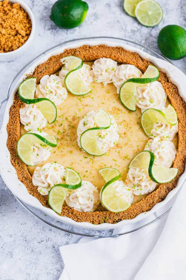 this key lime pie is made with a lime flavoured graham cracker crust, key lime pie filling and decorated with whipped cream, graham cracker crumbs, lime zest and lime twists