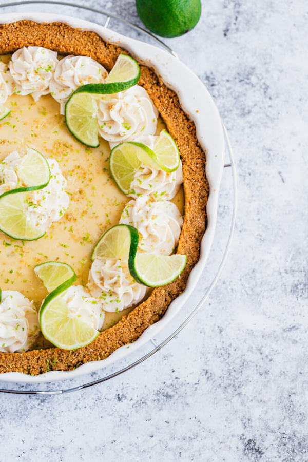 this key lime pie is made with a lime flavoured graham cracker crust, key lime pie filling and decorated with whipped cream, graham cracker crumbs, lime zest and lime twists