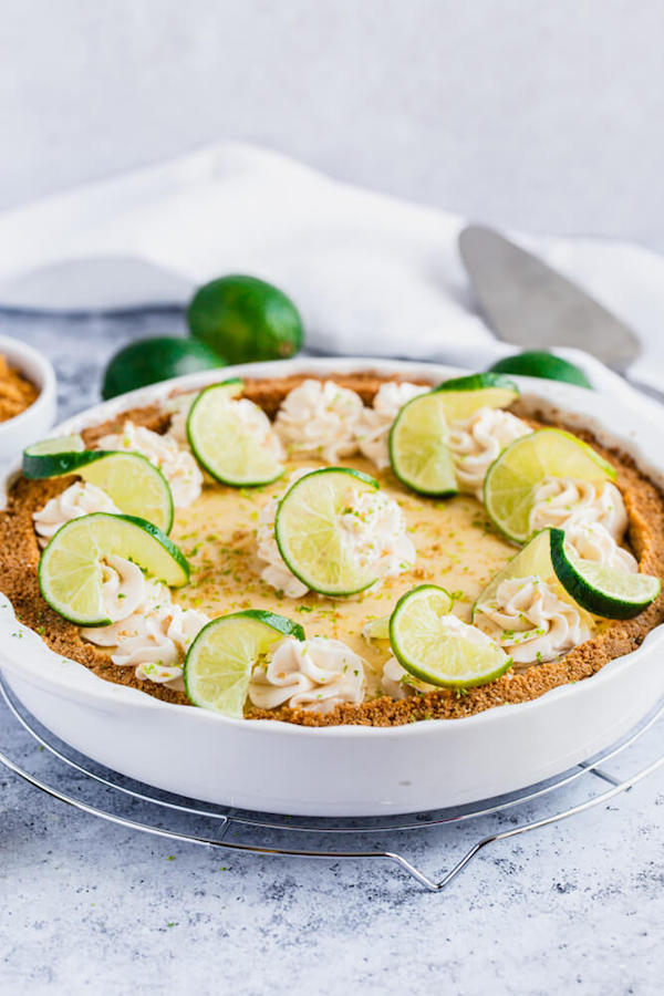 this key lime pie is made with a lime flavoured graham cracker crust, key lime pie filling and decorated with whipped cream, graham cracker crumbs, lime zest and lime twists