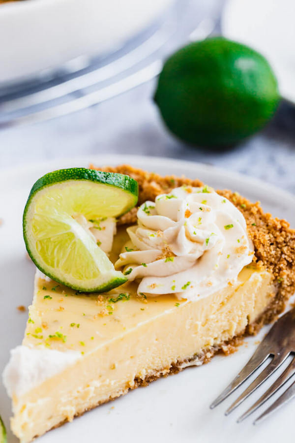 this key lime pie is made with a lime flavoured graham cracker crust, key lime pie filling and decorated with whipped cream, graham cracker crumbs, lime zest and lime twists