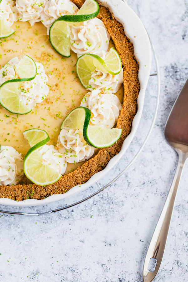 this key lime pie is made with a lime flavoured graham cracker crust, key lime pie filling and decorated with whipped cream, graham cracker crumbs, lime zest and lime twists