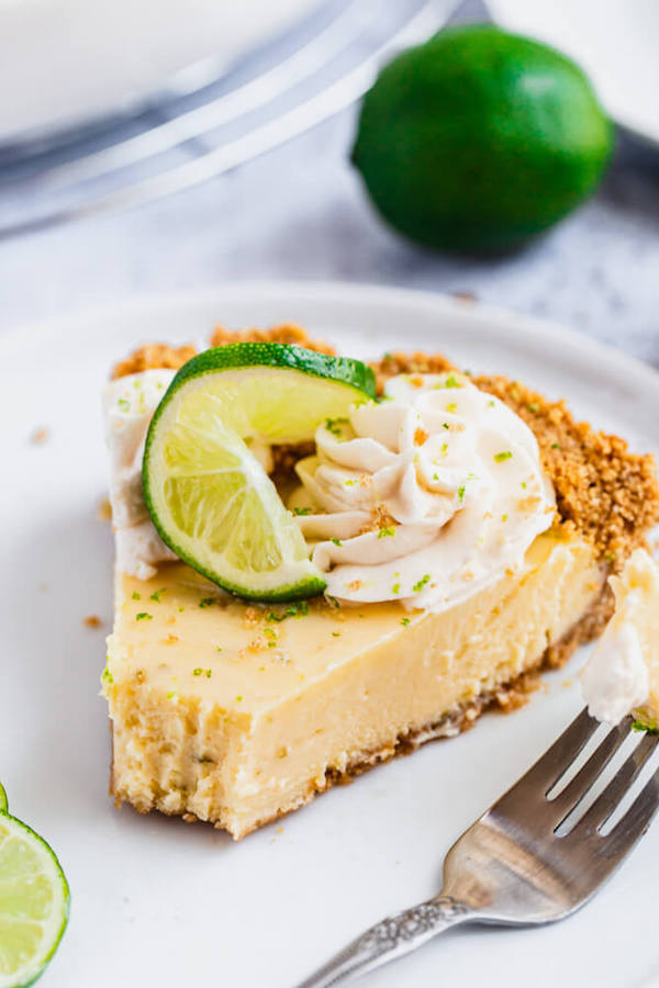 this key lime pie is made with a lime flavoured graham cracker crust, key lime pie filling and decorated with whipped cream, graham cracker crumbs, lime zest and lime twists