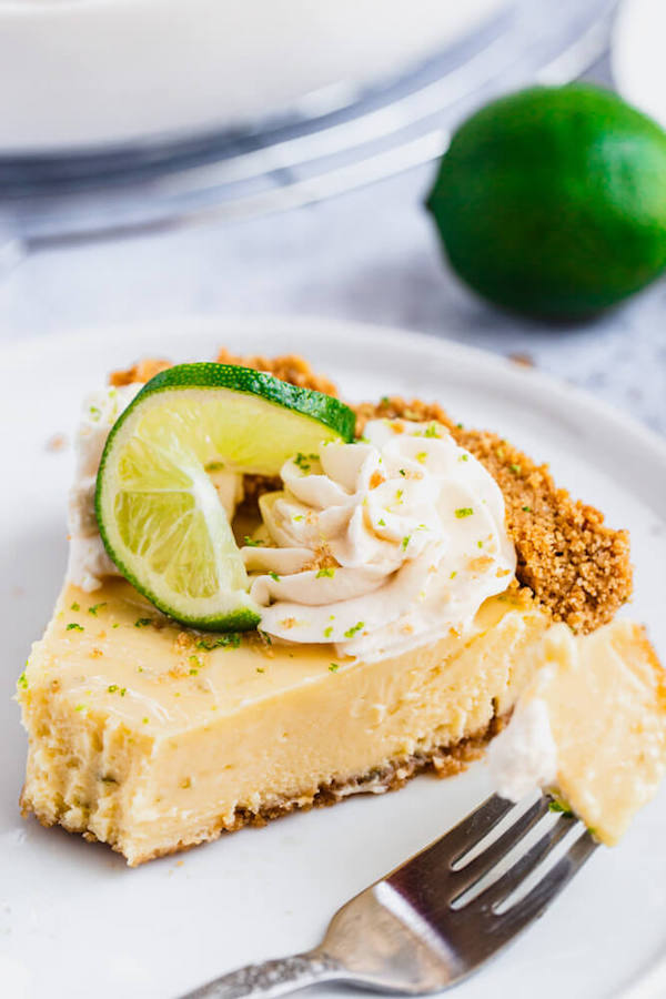 this key lime pie is made with a lime flavoured graham cracker crust, key lime pie filling and decorated with whipped cream, graham cracker crumbs, lime zest and lime twists