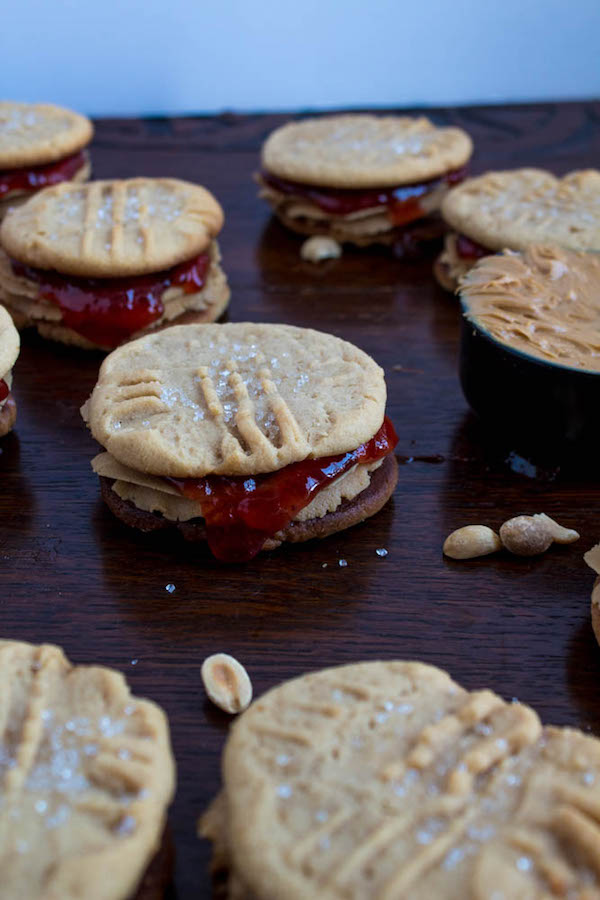 Soft and chewy peanut butter cookies filled with peanut butter frosting and strawberry jam. These Peanut Butter and Jelly Cookie Sandwiches are a sweet and amazing twist to the classic childhood favourite!