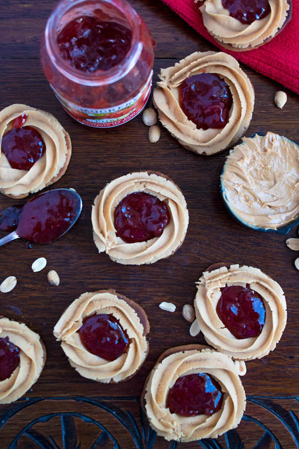 Soft and chewy peanut butter cookies filled with peanut butter frosting and strawberry jam. These Peanut Butter and Jelly Cookie Sandwiches are a sweet and amazing twist to the classic childhood favourite!