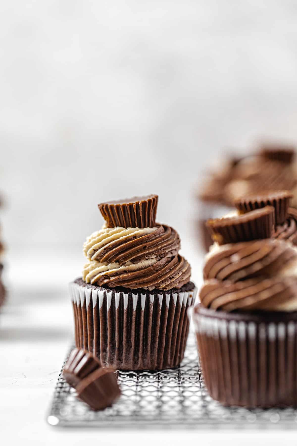 two cupcakes on a small rack with a mini Reese's cup in front of the one in the background