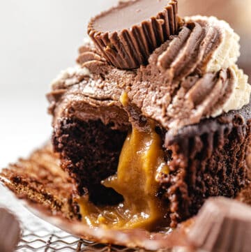 close up of cupcake with a bite taken out of it and peanut butter ganache flowing out