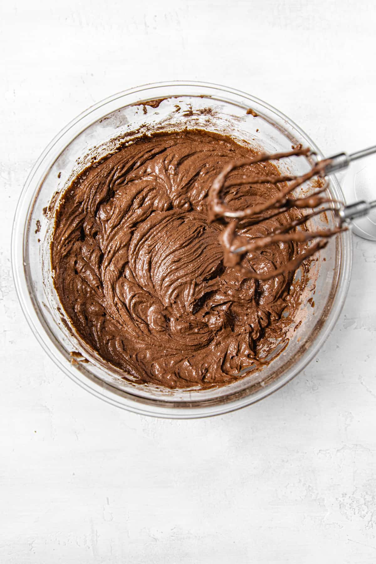 bowl of chocolate cupcake batter with hand mixer over it