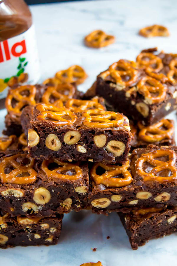 Salty meets sweet in these Nutella Pretzel Brownies! A perfectly fudgy Nutella brownie with roasted hazelnuts and salty pretzels mixed in. This decadent dessert will satisfy all of your salty and sweet cravings!