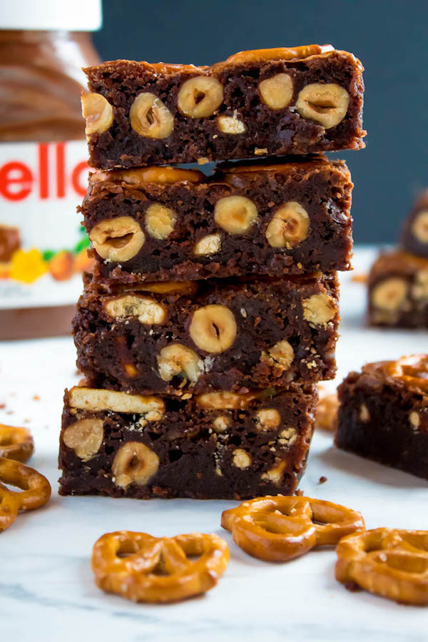 Salty meets sweet in these Nutella Pretzel Brownies! A perfectly fudgy Nutella brownie with roasted hazelnuts and salty pretzels mixed in. This decadent dessert will satisfy all of your salty and sweet cravings!