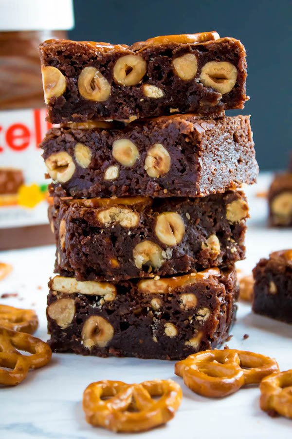 Salty meets sweet in these Nutella Pretzel Brownies! A perfectly fudgy Nutella brownie with roasted hazelnuts and salty pretzels mixed in. This decadent dessert will satisfy all of your salty and sweet cravings!