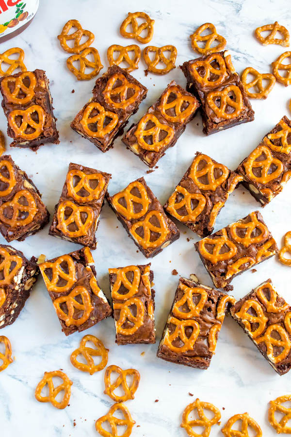 Salty meets sweet in these Nutella Pretzel Brownies! A perfectly fudgy Nutella brownie with roasted hazelnuts and salty pretzels mixed in. This decadent dessert will satisfy all of your salty and sweet cravings!