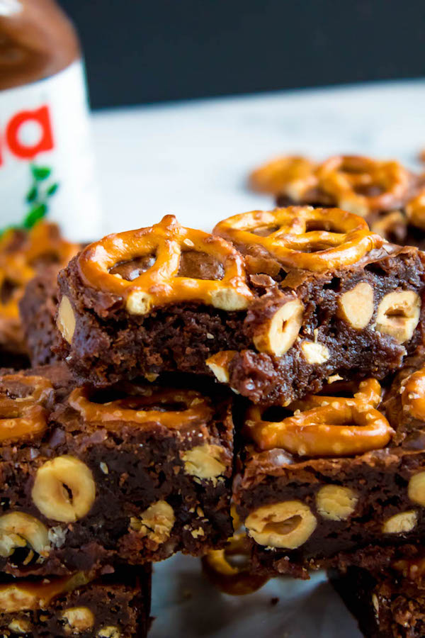 Salty meets sweet in these Nutella Pretzel Brownies! A perfectly fudgy Nutella brownie with roasted hazelnuts and salty pretzels mixed in. This decadent dessert will satisfy all of your salty and sweet cravings!