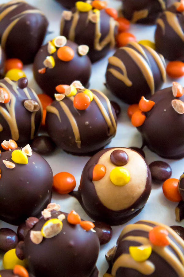 Reese's Pieces Peanut Butter Truffles— smooth and creamy peanut butter balls, loaded with mini Reese's Pieces, coated with dark chocolate and drizzled with melted peanut butter!