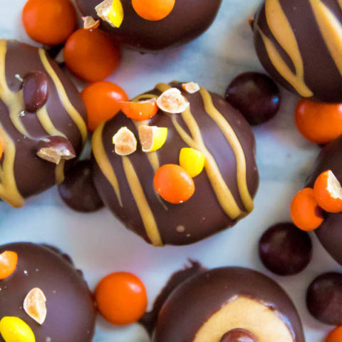 Reese's Pieces Peanut Butter Truffles— smooth and creamy peanut butter balls, loaded with mini Reese's Pieces, coated with dark chocolate and drizzled with melted peanut butter!