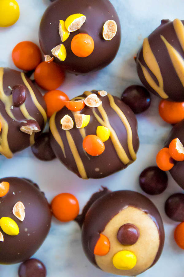 Reese's Pieces Peanut Butter Truffles— smooth and creamy peanut butter balls, loaded with mini Reese's Pieces, coated with dark chocolate and drizzled with melted peanut butter!