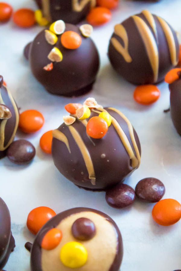 Reese's Pieces Peanut Butter Truffles— smooth and creamy peanut butter balls, loaded with mini Reese's Pieces, coated with dark chocolate and drizzled with melted peanut butter!