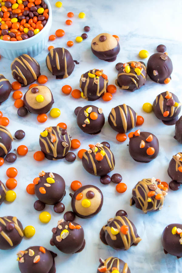 Reese's Pieces Peanut Butter Truffles— smooth and creamy peanut butter balls, loaded with mini Reese's Pieces, coated with dark chocolate and drizzled with melted peanut butter!