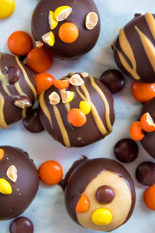 Reese's Pieces Peanut Butter Truffles— smooth and creamy peanut butter balls, loaded with mini Reese's Pieces, coated with dark chocolate and drizzled with melted peanut butter!