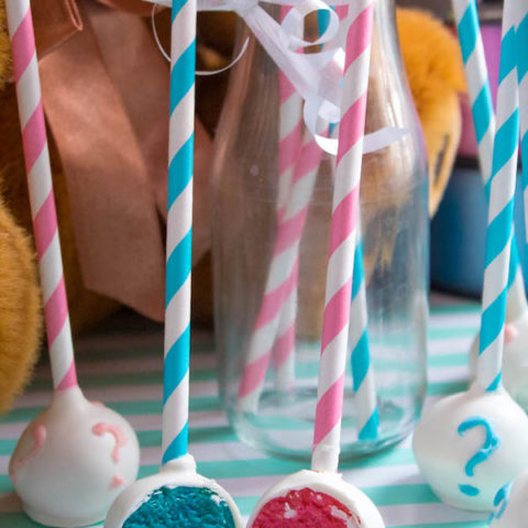 These Gender Reveal Cake Pops are a fun and cute way to surprise your baby shower guests! Once they bite into it, the pink or blue cake inside will reveal if it's a boy or girl!