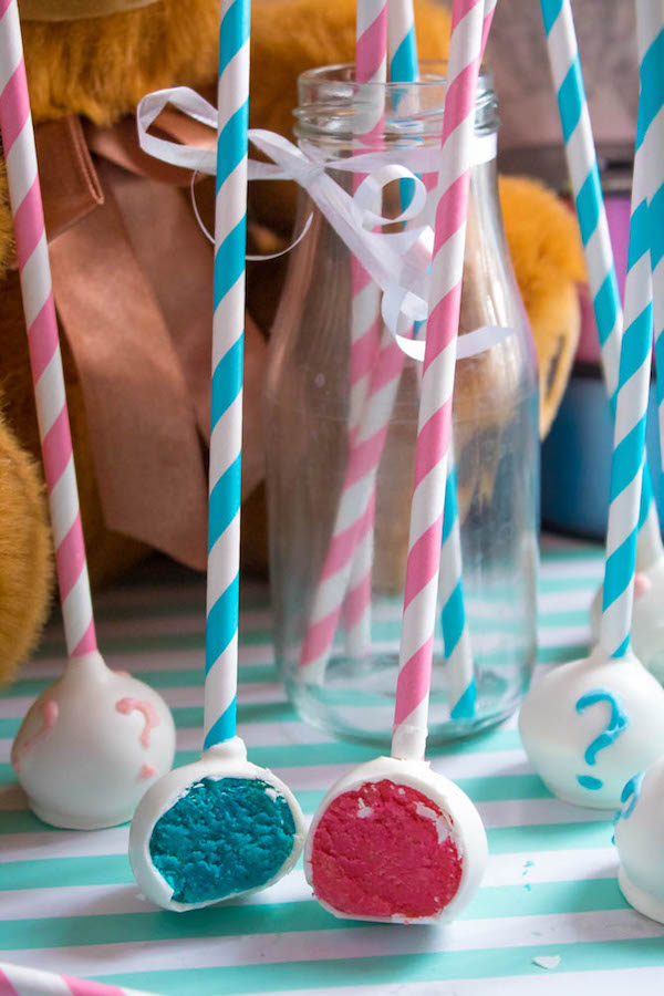 These Gender Reveal Cake Pops are a fun and cute way to surprise your baby shower guests! Once they bite into it, the pink or blue cake inside will reveal if it's a boy or girl!