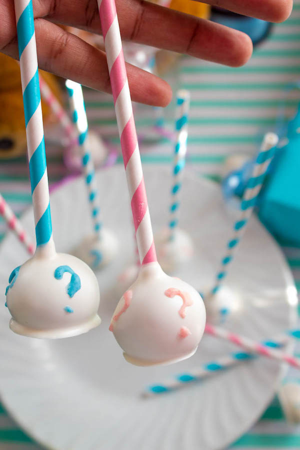 These Gender Reveal Cake Pops are a fun and cute way to surprise your baby shower guests! Once they bite into it, the pink or blue cake inside will reveal if it's a boy or girl!