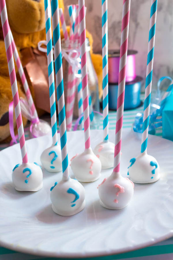 These Gender Reveal Cake Pops are a fun and cute way to surprise your baby shower guests! Once they bite into it, the pink or blue cake inside will reveal if it's a boy or girl!