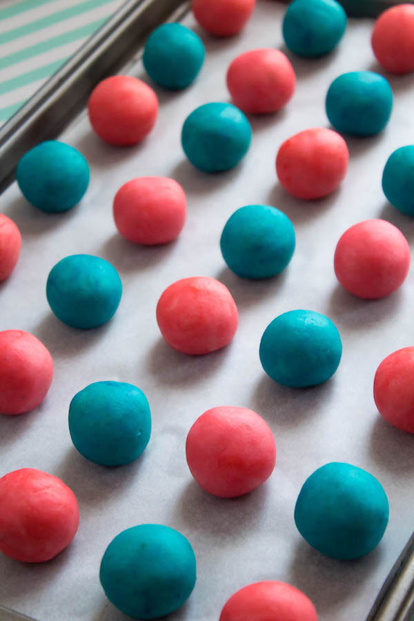 These Gender Reveal Cake Pops are a fun and cute way to surprise your baby shower guests! Once they bite into it, the pink or blue cake inside will reveal if it's a boy or girl!