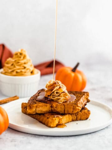 pumpkin French toast topped with icing sugar, maple syrup and whipped pumpkin spice honey butter