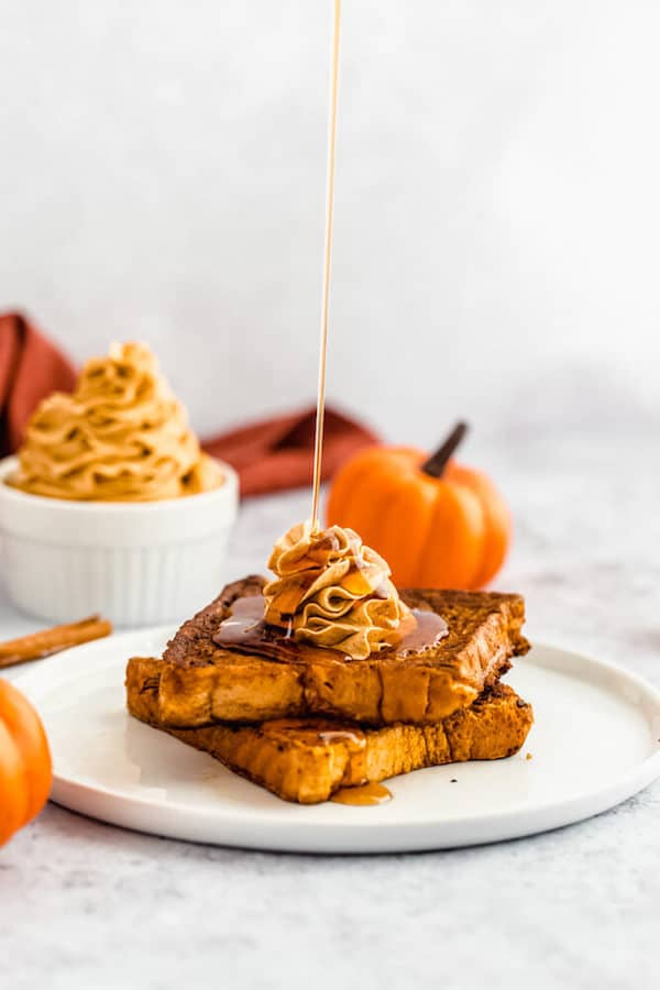 pumpkin French toast topped with icing sugar, maple syrup and whipped pumpkin spice honey butter