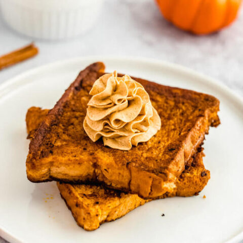 pumpkin French toast topped with icing sugar, maple syrup and whipped pumpkin spice honey butter