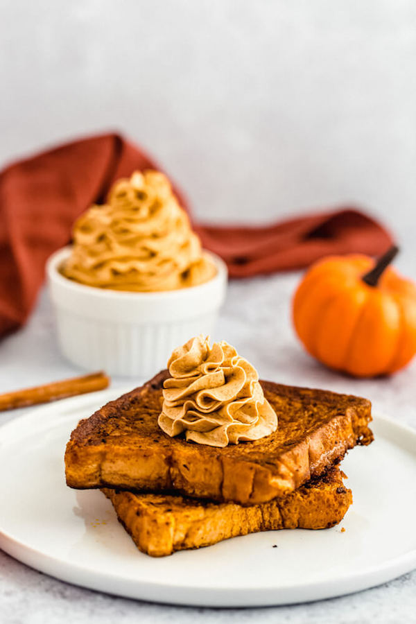 pumpkin French toast topped with icing sugar, maple syrup and whipped pumpkin spice honey butter