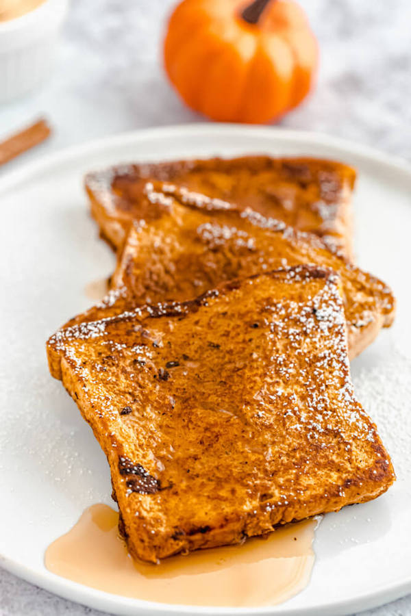 pumpkin French toast topped with icing sugar and maple syrup 
